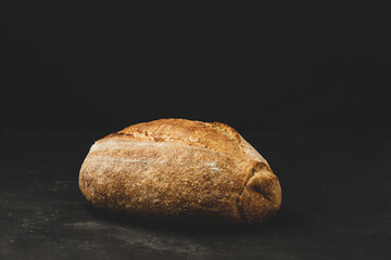 Rustic artisan crusty bread on black background