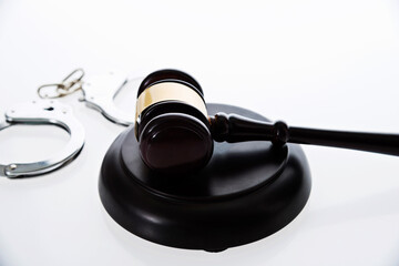 Wooden judge gavel and police handcuffs isolated on white background