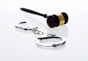 Wooden judge gavel and police handcuffs isolated on white background