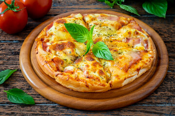 Pizza with bacon and mozzarella cheese on wooden plate