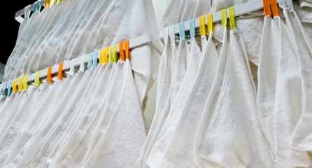 Many white towels hanging on a rack