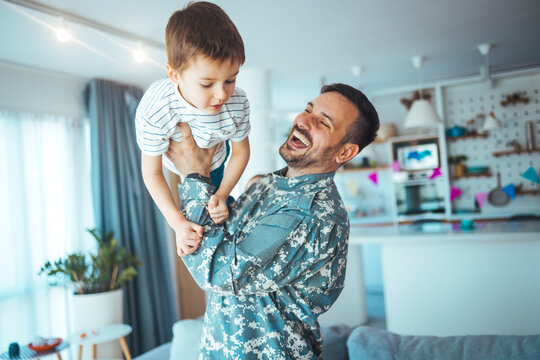 Happy soldier play with his son. Soldier enjoying at home with children. My Hero is back home. Little boy meeting his military father at home. Memorial Day celebration..