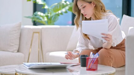 Business woman hand using calculator to calculate the company's financial results and budget.asian young woman calculate tax income and expenses, bills, credit card for payment or payday at home
