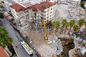 Top view of the demolition of an old house with industrial excavator