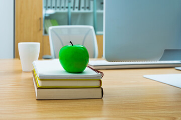 Green apple on desk of office room