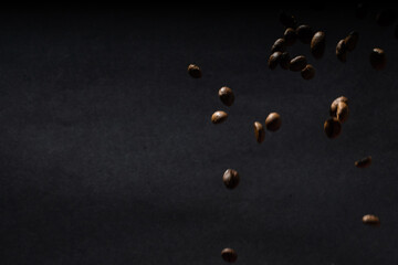Pile coffee beans isolated on black background and texture, top view.