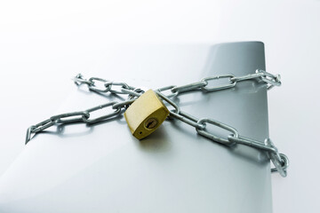 Chain with padlock around laptop isolated on white background