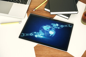 Top view of modern digital tablet monitor with robotics technology and world map hologram. Research and development software concept. 3D Rendering