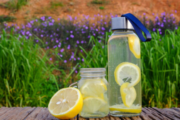 Freshness concept. Lemonade with  lemon slices in a jar on a rustic  wooden background. Close up.