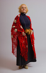 a woman in a knitted red shawl and bagels stands in full growth on a white background