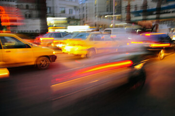 blurred background with light of taxi and cars driving on road at night with speed motion