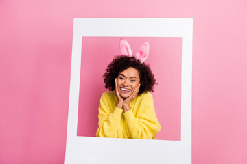 Photo of funny dreamy lady wear yellow sweater easter headband arms cheeks tacking photo isolated pink color background