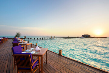 Fototapeta na wymiar Outdoor restaurant at the beach Romantic Sunset view in Maldives Island