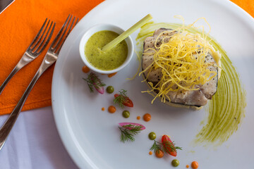 Delicious Asian style teriyaki grilled fish steak with green chutney on a white plate.