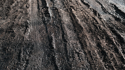 Dirt road surface, footprints and tire marks outdoors. Countryside land in seasonal weather