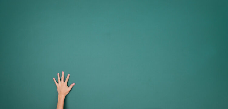 Raised hand in front of chalkboard
