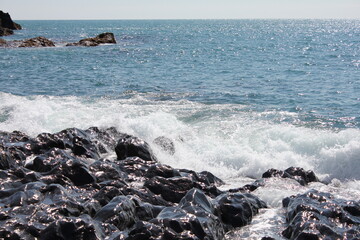 Surreal scenery of breaking waves at shiny lava cliffs, sunny summer day (horizontal), Djupalonssandur, Iceland