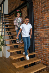 Fototapeta premium Boy and girl walking down stairs smiling at camera