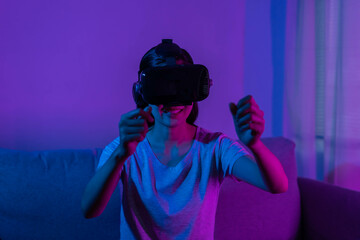 Recreation, asian young woman wearing VR headset or visual reality goggles, glasses or gadget, play video game of simulator future,futuristic while wearable, sitting on couch, sofa.