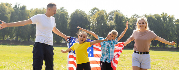 Happy family in field with USA, american flag