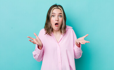 pretty caucasian woman open-mouthed and amazed, shocked and astonished with an unbelievable surprise