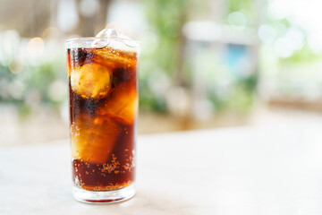 Close up shoot with copyspace of cola soda with ice in a drinking glass. 