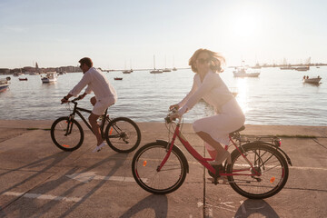 Senior couple enjoying a beautiful morning together riding a bike by the sea. Selective focus