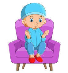The happy islamic boy is praying on the sofa