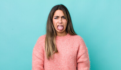 pretty hispanic woman feeling disgusted and irritated, sticking tongue out, disliking something nasty and yucky - obrazy, fototapety, plakaty