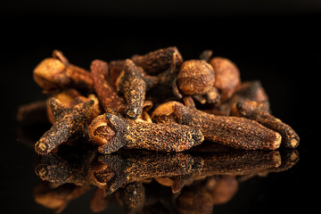 Bunch of whole cloves reflecting on black surface
