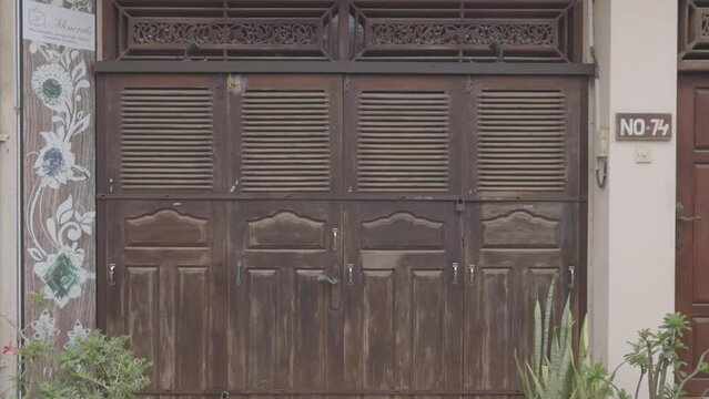 Antique wooden doors in colonial style. Beautiful wooden doors. Old wooden surface. Detail of hinge on old wooden door in historical city. 120 fps video, ProRes 422, 10 bit, ungraded C-LOG