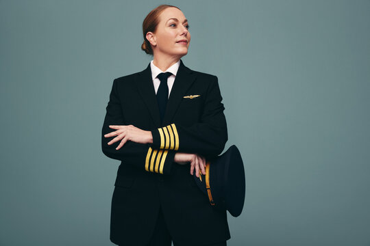 Cheerful airline pilot looking away thoughtfully