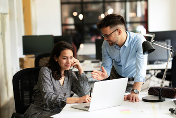 Colleagues in office. Businesswoman and businessman discussing work in office.