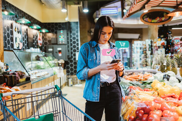 Young brunette woman looking at mobile phone