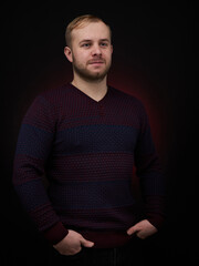 Fototapeta premium vertical portrait blond man on a dark background, in a jacket