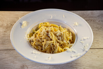 italian pasta served in a hat plate with the addition of parmesan