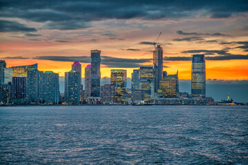 Fototapeta premium Sunset skyline of Jersey City as seen from a ferry boat tour aound New York City.