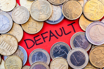 Word "default", written in black on a red surface, and coins around it. Economic sanctions for war. Economic difficulties and public debt. 
