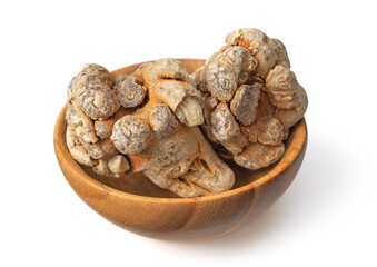 Dried notoginseng roots in the wooden bowl, isolated on the white background.