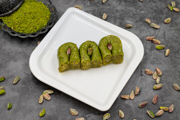 Pistachio Baklava on a dark background. Mediterranean cuisine delicacies. Close-up baklava. local name fistikli bulbul