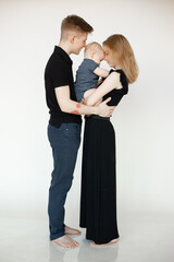 Vertical portrait of smiling calm barefoot woman, man, baby, hugging and spending time together. Reunion family, side
