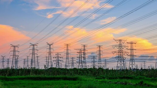 High voltage electric towers at sunset. Transmission power line. Electricity pylons and sky clouds background.