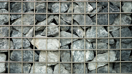 Abstract stones in metal squre cage wall for decoration