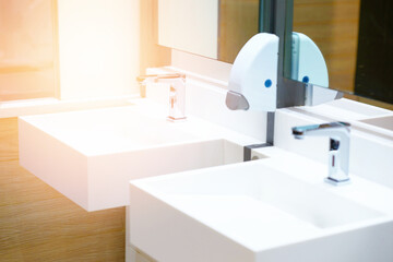 White ceramic sink and water tap with soap dispenser in bath room or toilet