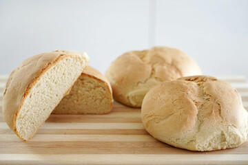Close-up of homemade bread on wooden table. Rising price of basic needs.