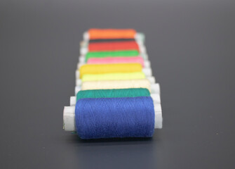 different color yarn on spool, yarn on tube, cotton, wool, linen thread, isolate on black background