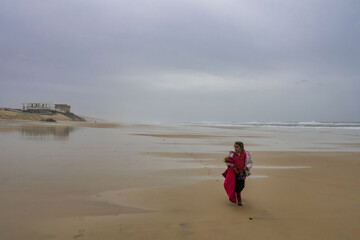 Fototapeta na wymiar Little girl walking on the sand at La Teste de Buch, France/Petite fille marchant sur le sable à la Teste de Buch, France