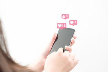 スマホを持つ女性の手許