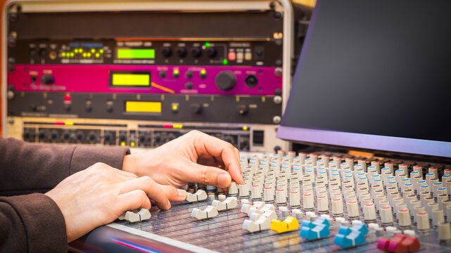 sound engineer hands working on audio mixing console in studio. post production, broadcasting, recording concept