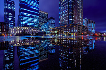 Fototapeta na wymiar Night city view of business buildings around the Marunouchi side of Tokyo Station after rain. Reflection photo with beautiful specular reflection.